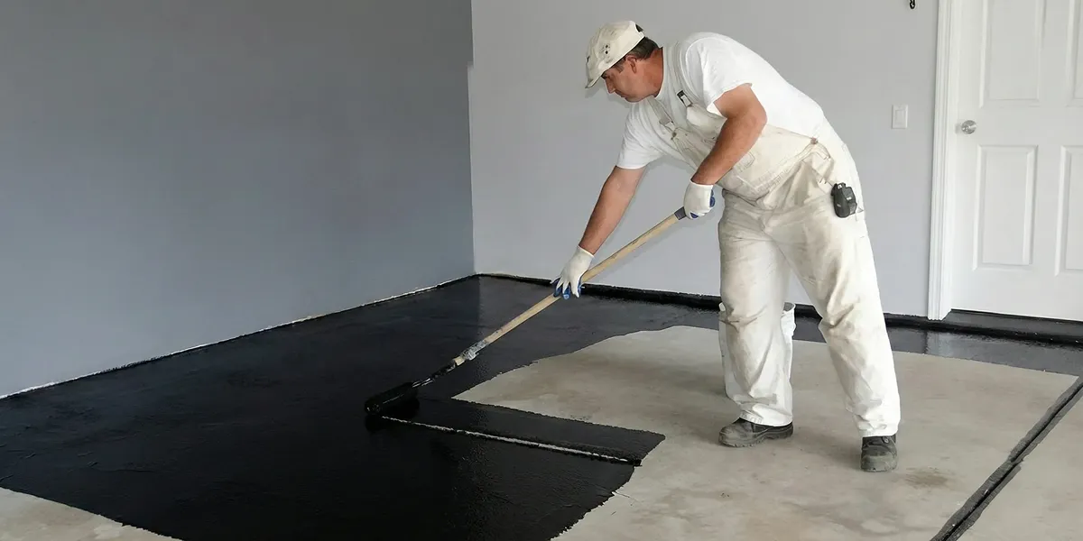 basement waterproofing professional applying waterproof coating to protect a basement floor in Tucson, AZ