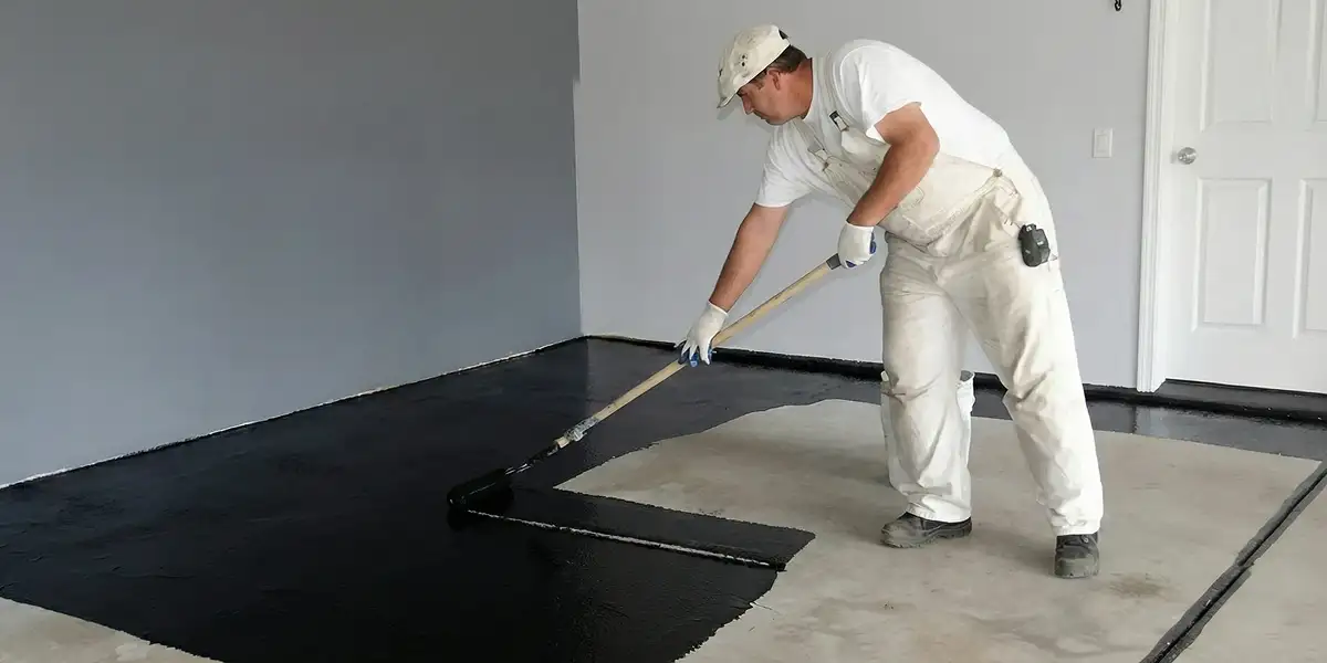 basement waterproofing professional applying waterproof coating to protect a basement floor in Tucson, AZ