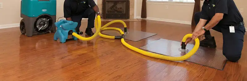 emergency water removal technicians extracting standing water from a home using professional equipment in Tucson, AZ